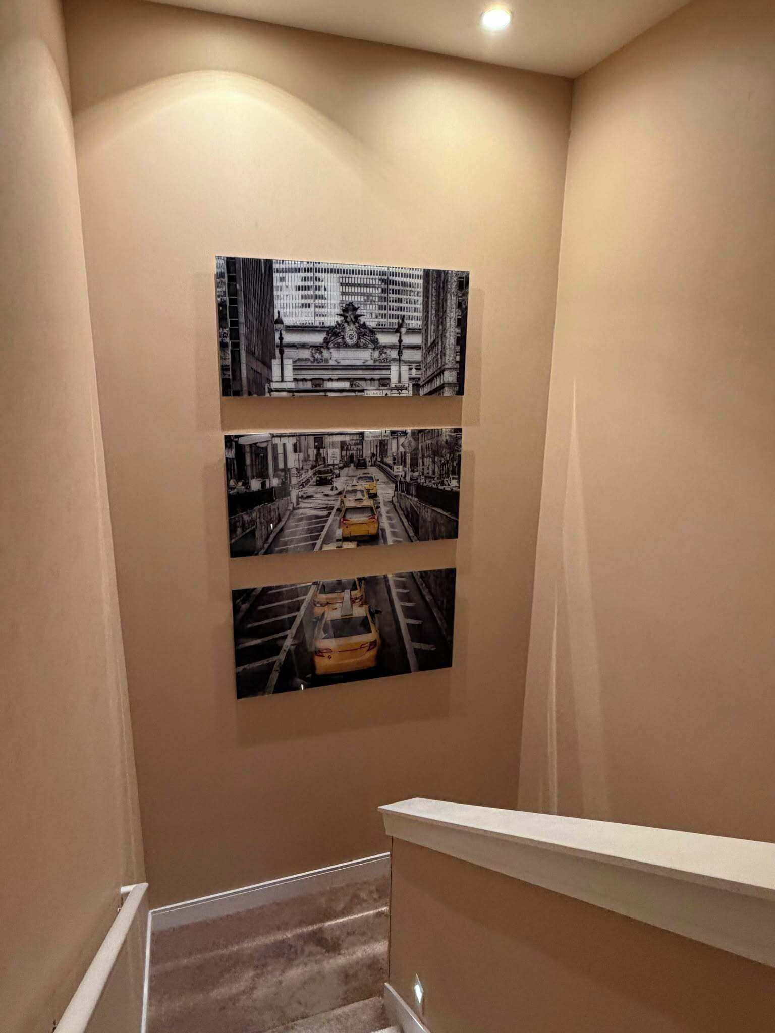 Una escalera con una fotografía blanco y negro en la pared que muestra una calle de la ciudad.