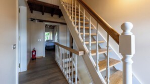 A wooden staircase with white balusters leading to a second-floor landing. - Villa Krat (Holsbeek)