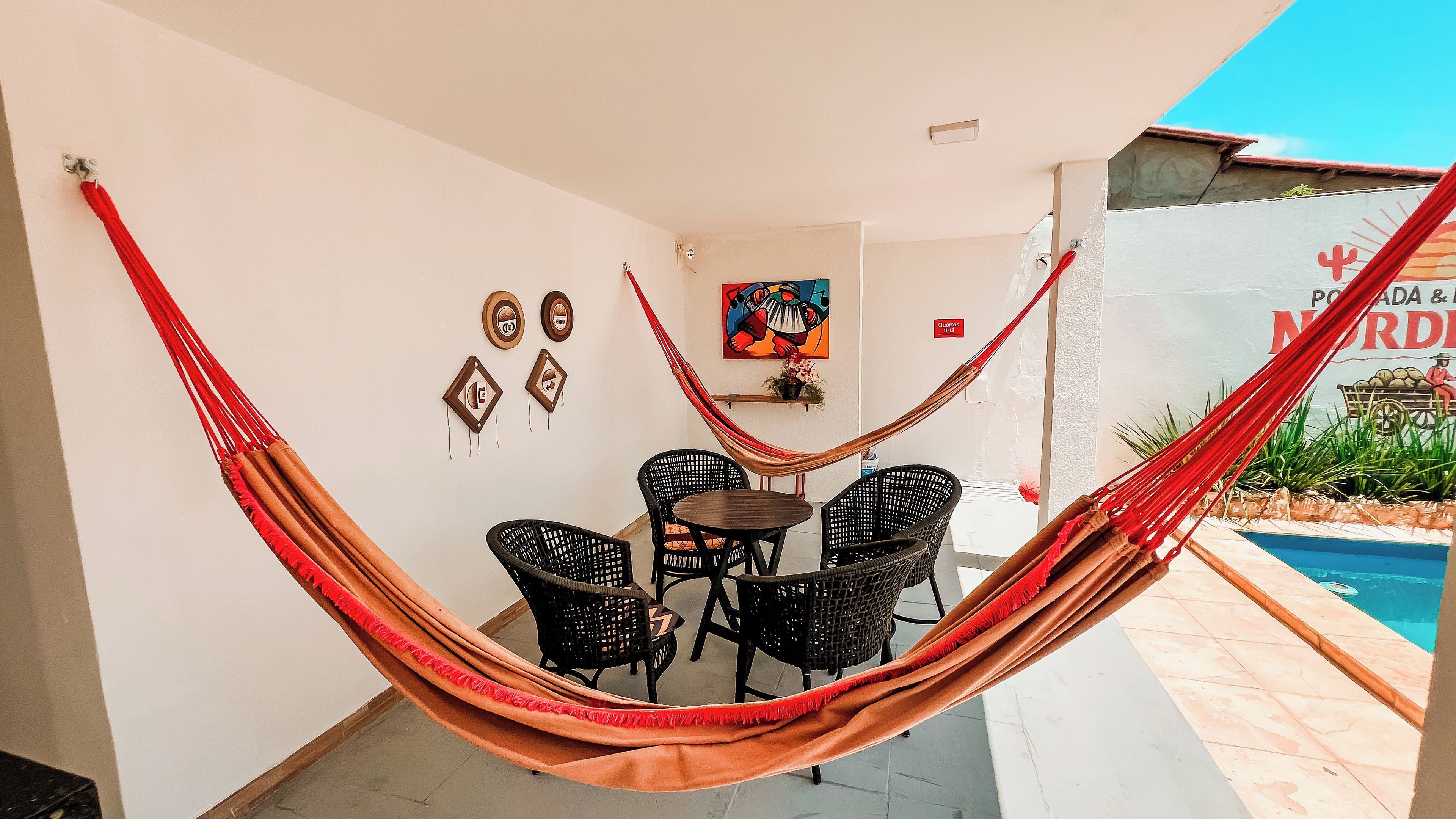 A hammock chair set up in a patio area with a pool in the background.