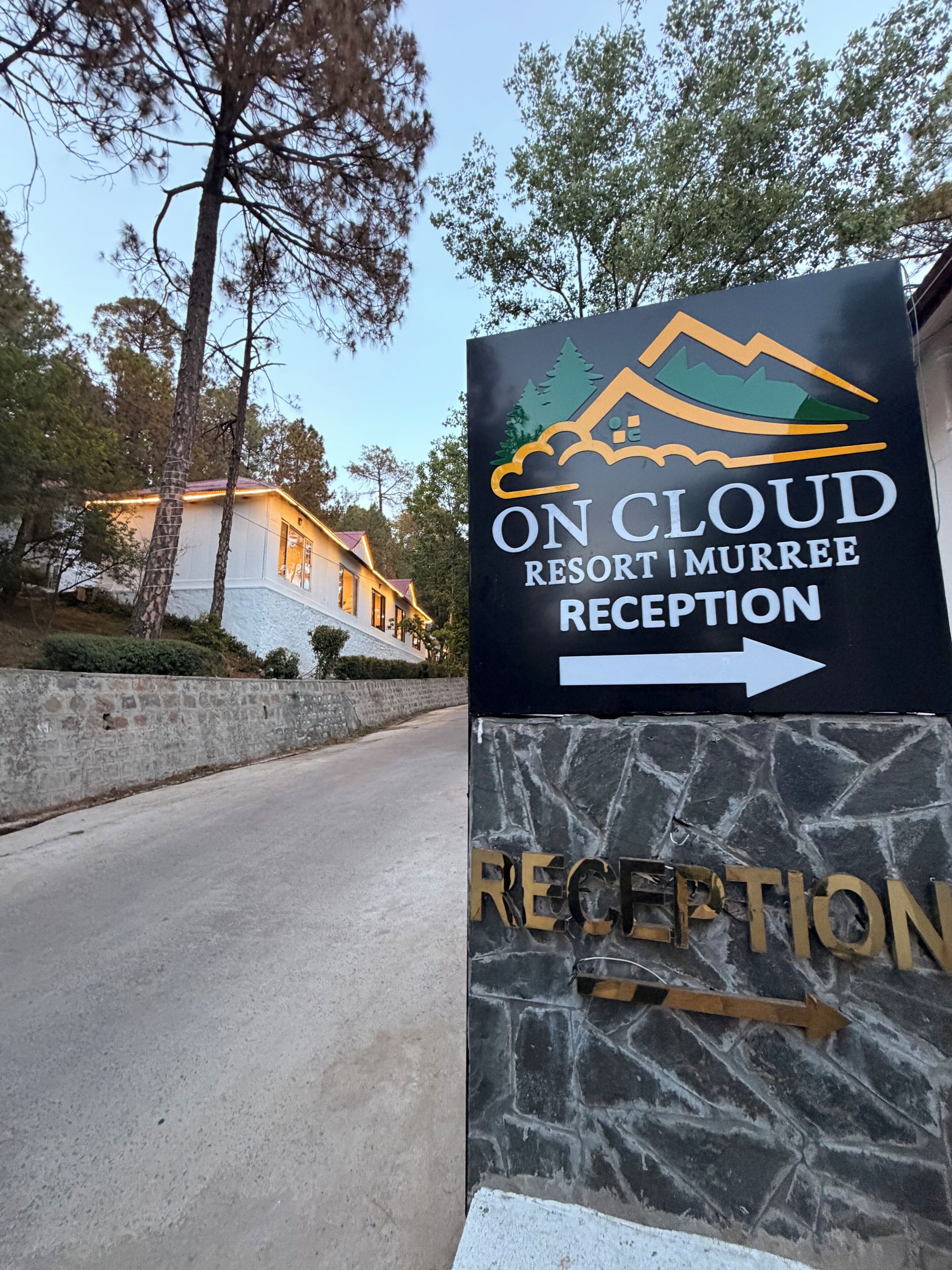 A reception sign for On Cloud Resort Murreee with a mountain graphic and an arrow pointing right.