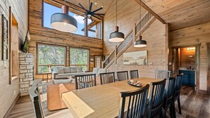 Un'ampia cabina in legno arredata con zona pranzo, una scala e vista sull'esterno.