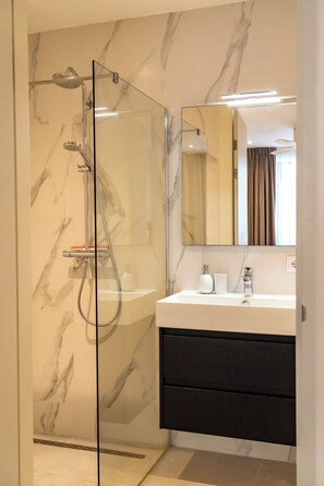 Regadera, secadora de cabello, toallas, papel de baño 