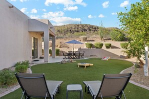 A patio with a table and chairs, a small lawn, and a view of a hilly landscape. - Hidden Oasis Intimate 3 BR Home/ Private Pool/ Jacuzzi/ Fire Pit/ Glendale (Glendale)