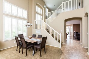 A dining area with a table and chairs, a chandelier, and a staircase leading to an upper level. - The Magic on Midway Luxury Home in Glendale - 5 BR/2.5 Bath/Unique Game Room (Glendale)