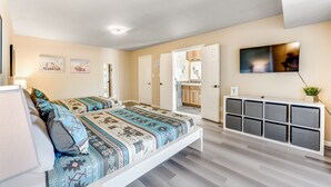 Camera da letto moderna con un letto grande, un comodino, un armadio e una TV a parete.