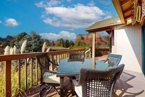 A patio with wicker furniture and a view of red rock formations. - Arizona-themed home with huge deck, private hot tub, central AC, W/D, media room (Sedona)