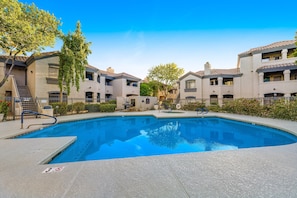 A swimming pool surrounded by multi-story buildings with balconies, a clear sky, and a no diving sign on the poolside. - Dog-friendly condo close to the city with central AC, shared pool, & hot tub (Scottsdale)