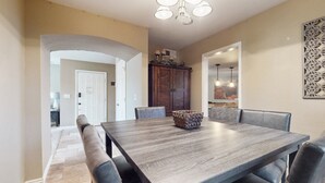 A dining area with a large rectangular table, six chairs, and a decorative centerpiece. - Charming, dog-friendly home only minutes to Old Town with pool & custom bar (Scottsdale)