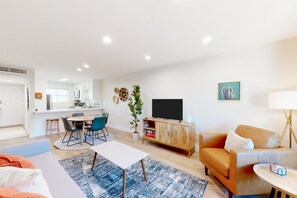 A modern living room with a sofa, coffee table, and dining area. - 2-story dog-friendly condo with patio, outdoor pool, W/D, streaming, partial AC (Scottsdale)
