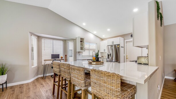 A modern kitchen with a central island, bar stools, and a built-in refrigerator. - Desert stay with a private pool, grill, washer/dryer, & central AC (Glendale)