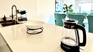 Et moderne køkken med kaffemaskine, en skål og en vask.