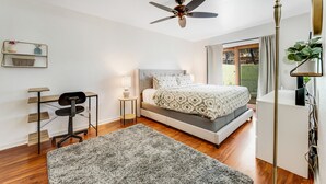 A modern bedroom with a bed, desk, chair, and ceiling fan. - Dog-friendly townhouse with enclosed patio, outdoor pool, mtn views, W/D, AC (Phoenix)