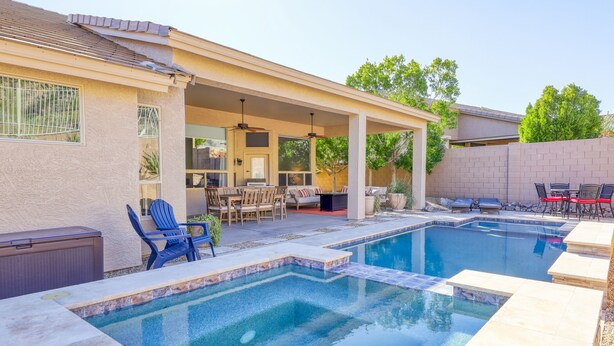 A backyard with a swimming pool, patio furniture, and a covered seating area. - Private desert dream home with enclosed yard, pool, furnished lanai, & grill (Mesa)