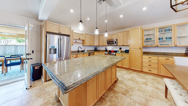 A modern kitchen with granite countertops, wooden cabinets, stainless steel appliances, and pendant lighting. - Modern home with open layout, private pool, & washer/dryer - dog friendly (Phoenix)