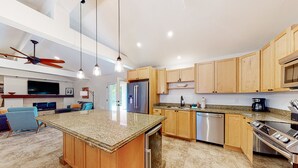 A modern kitchen with granite countertops, wooden cabinets, stainless steel appliances, and pendant lighting. - Modern home with open layout, private pool, & washer/dryer - dog friendly (Phoenix)