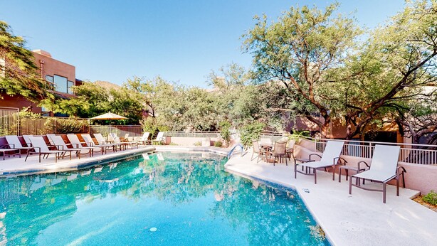 A swimming pool with lounge chairs and a patio area. - Beautiful condo with stunning views, pool, hot tub, balcony, W/D, AC (Tucson)