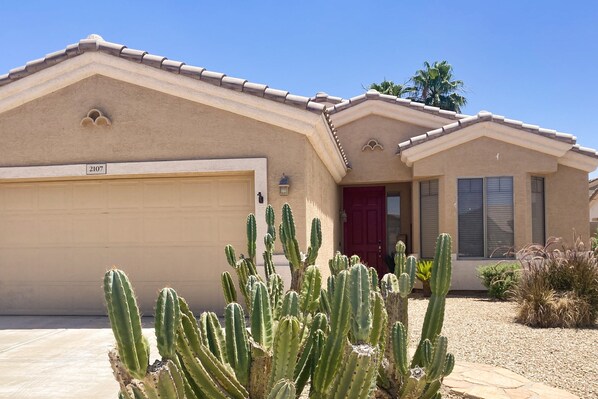 A house with a beige facade, a red door, and a garage numbered 2107. - inviting home with private pool, patio, grill, washer/dryer, & central AC (Chandler)