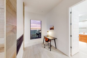 A modern office space with a desk, chair, and large window.