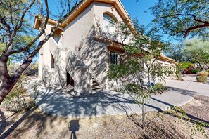 A stucco building with a stone facade, a tiled roof, and a small porch.