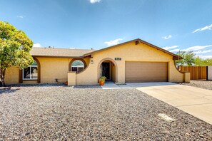 A single-story house with a beige exterior, a garage, and a gravel driveway. - WeeCasa | Dog-friendly house in Chandler with private heated pool, hot tub, AC (Chandler)