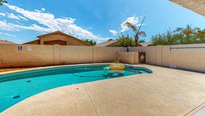 A swimming pool with a clear blue water, a yellow inflatable float, and a concrete deck. - Updated home with private pool, enclosed yard, covered patio, grill, & W/D (Glendale)