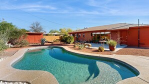 A residential property with a swimming pool, a red brick house, and a well-maintained garden. - Sun-soaked & charming dog-friendly retreat with private pool, large patio, & W/D (Tucson)