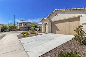 A residential street with houses, a clear sky, and a well-maintained driveway.