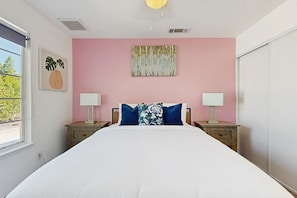 A bedroom with a large bed, two bedside tables, a window, and artwork on the walls. - Updated mid-century gem with private pool, spa, gas grill, and free WiFi (Palm Springs)
