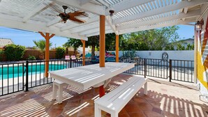 A covered outdoor area with a pool, white tables, and benches. - Updated mid-century gem with private pool, spa, gas grill, and free WiFi (Palm Springs)