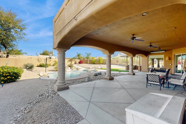 An outdoor patio area with a pool, seating, and a covered section with ceiling fans. - Your North Scottsdale Escape — Poolside Comfort, Easy Living & Prime Location (Scottsdale)