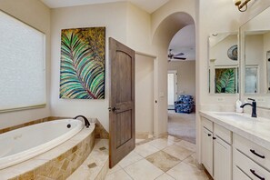 A bathroom with a freestanding bathtub, a wooden door, a large mirror, and a decorative leaf painting on the wall. - Your North Scottsdale Escape — Poolside Comfort, Easy Living & Prime Location (Scottsdale)