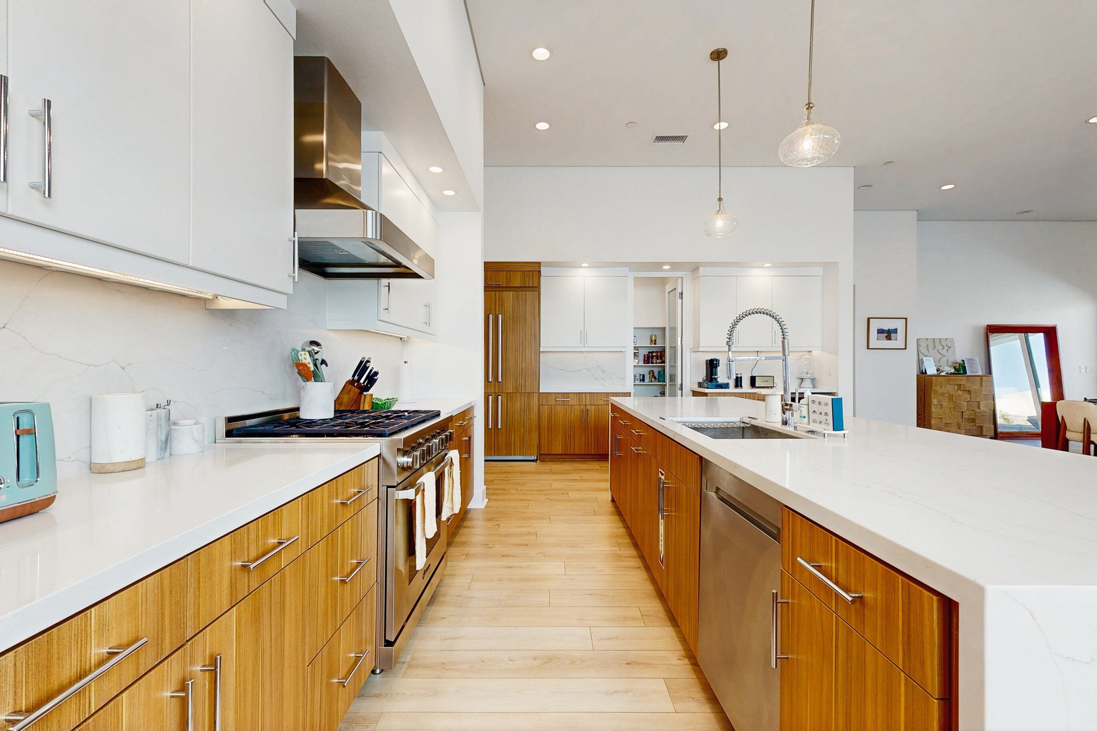 Une cuisine moderne avec des meubles en bois, des appareils en acier inoxydable et un grand îlot central.