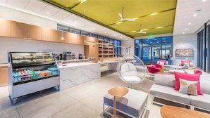 A modern hotel lobby with a central counter, seating area, and a large window. - Desert days, cozy nights, and poolside delights await at this stylish home. (Palm Springs)