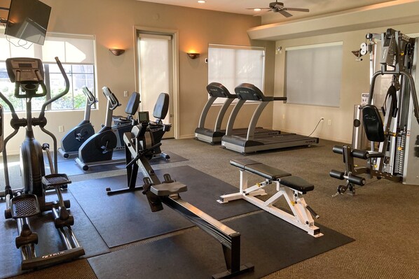 A gym with various exercise equipment including treadmills, a stationary bike, and weight machines. - Dog-friendly mountain view condo with pool, gym, grill, fireplace, & sunroom (Tucson)