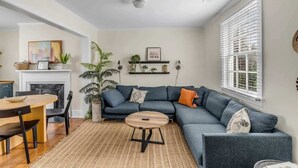 Ein modernes Wohnzimmer mit einem Ecksofa, einem runden Couchtisch und einem Kamin.