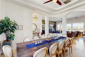 A dining area with a wooden table, chairs, and a large plant. - Dog-Friendly Desert Oasis w/ a Gourmet Kitchen, Private Pool, & Putting Green (Marana)