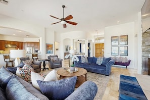 A spacious living area with a fireplace, sofas, and a ceiling fan. - Dog-Friendly Desert Oasis w/ a Gourmet Kitchen, Private Pool, & Putting Green (Marana)
