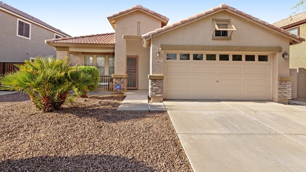 A single-story house with a garage, a small front porch, and a palm tree in the driveway. - Desert oasis with an enclosed yard, firepit, washer/dryer, and central AC (Gilbert)