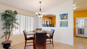A dining area with a table, chairs, a chandelier, and a potted plant. - Desert oasis with an enclosed yard, firepit, washer/dryer, and central AC (Gilbert)