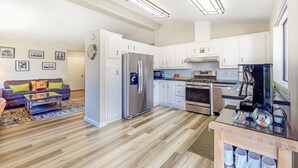 A modern kitchen with white cabinets, stainless steel appliances, and a coffee station. - Gated community home with 2 pools, hot tubs, private patio, AC, & W/D (Palm Desert)