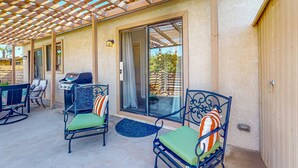 An outdoor patio with a pergola, seating, and a grill area. - Gated community home with 2 pools, hot tubs, private patio, AC, & W/D (Palm Desert)