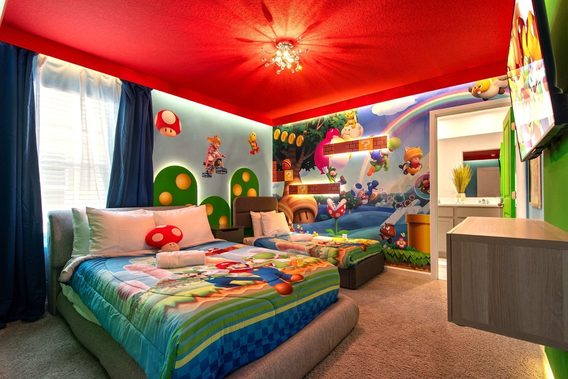 Une chambre d’enfant avec deux lits, un ventilateur de plafond et une fresque murale représentant des personnages de dessins animés.