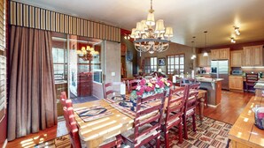 Une cuisine spacieuse avec des meubles en bois, un îlot central et un lustre.