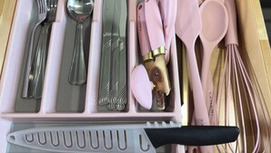 A drawer with a pink utensil organizer containing forks, spoons, a whisk, and a spatula. - Pretty in pink studio/Montrose HTX/Free parking + WIFI (Houston)