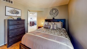 A bedroom with a bed, dresser, and artwork on the walls. - Gated-entry condo with central location, central AC, & private W/D (Phoenix)