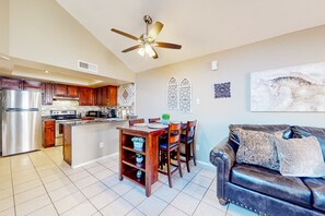 A spacious kitchen with wooden cabinets, a stainless steel refrigerator, and a dining area with a table and chairs. - Gated-entry condo with central location, central AC, & private W/D (Phoenix)