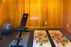 Una palestra con una panca, una palla ginnastica e un tappetino fantasia.