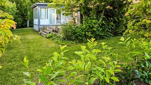 A well-maintained garden with a small shed, lush green grass, and various shrubs. - Cozy home in Lemvig with WiFi (Lemvig)