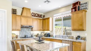Una cocina con armarios de madera, encimera de granito y lavavajillas de acero inoxidable.