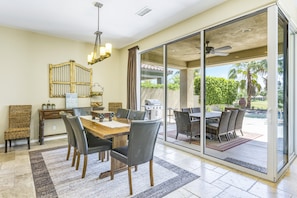 A dining area with a wooden table, chairs, and a chandelier. - Updated, Dog-friendly, fairway-view home with private lagoon pool & spa  - 3BR (La Quinta)
